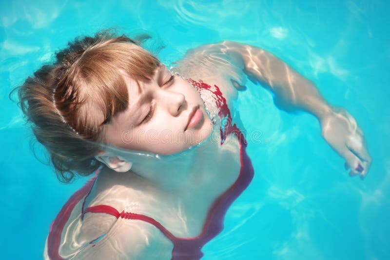 La petite fille blonde nage décontracté avec les yeux fermés photo libre de droits La petite fille blonde nage décontracté avec les yeux fermés photo libre de droits