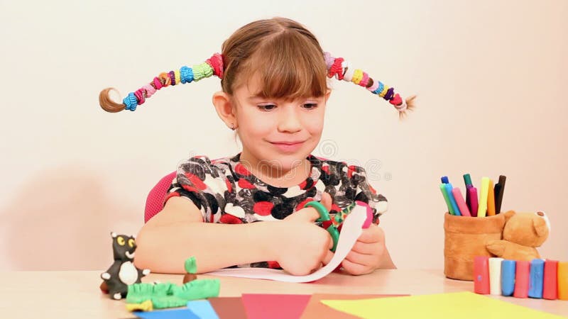 La petite fille fait la moustache de papier