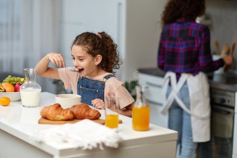 La Petite Fille Heureuse Et Excitée Mange Un Petit Déjeuner Sain Avec