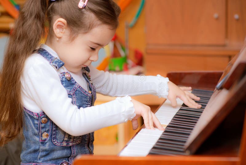 La petite fille joue le piano photos libres de droits La petite fille joue le piano photos libres de droits