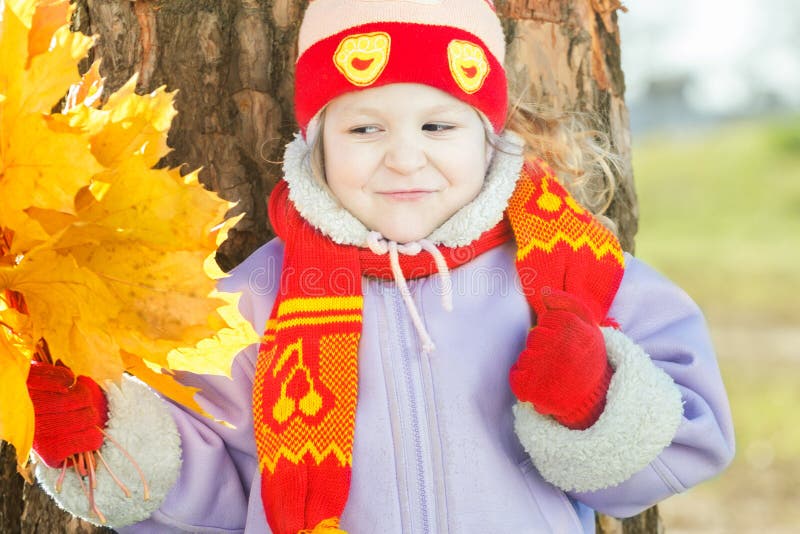 La petite fille jugeant jaune avec des feuilles d'automne d'or lient le portrait extérieur disponible photo libre de droits