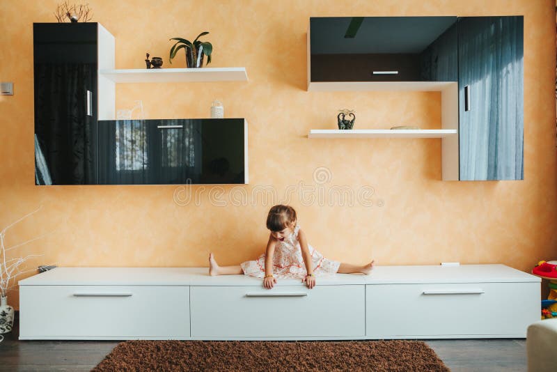 La petite fille s'asseyant sur la ficelle s'est dédoublée sur des meubles yoga images libres de droits La petite fille s'asseyant sur la ficelle s'est dédoublée sur des meubles yoga images libres de droits