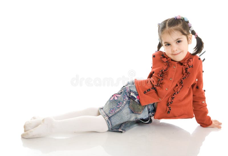 La petite fille s'asseyante d'isolement sur un blanc photos stock