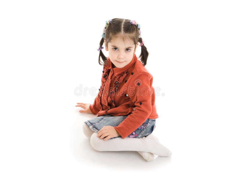 La petite fille s'asseyante d'isolement sur un blanc images libres de droits