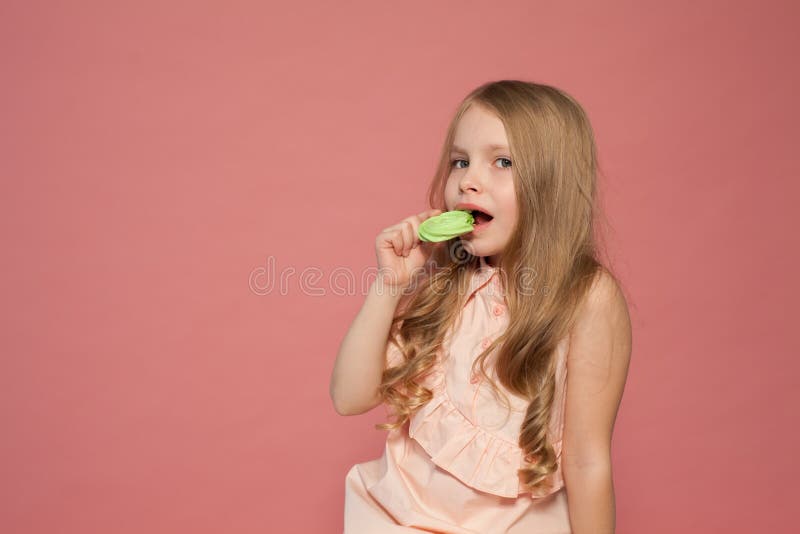 La petite fille tient à disposition une sucrerie douce de gâteau de petit gâteau image libre de droits La petite fille tient à disposition une sucrerie douce de gâteau de petit gâteau image libre de droits