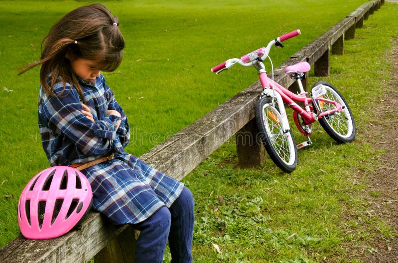 La petite fille triste ne savent pas monter un vélo image libre de droits La petite fille triste ne savent pas monter un vélo image libre de droits
