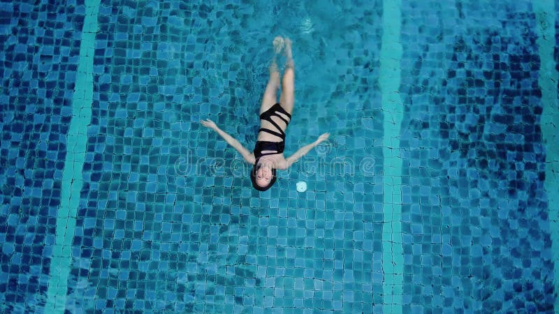 La photo aérienne de vue de dessus d'un modèle sexy séduisant dans des maillots de bain noirs apprécie vous détendre dans la pisci banque de vidéos