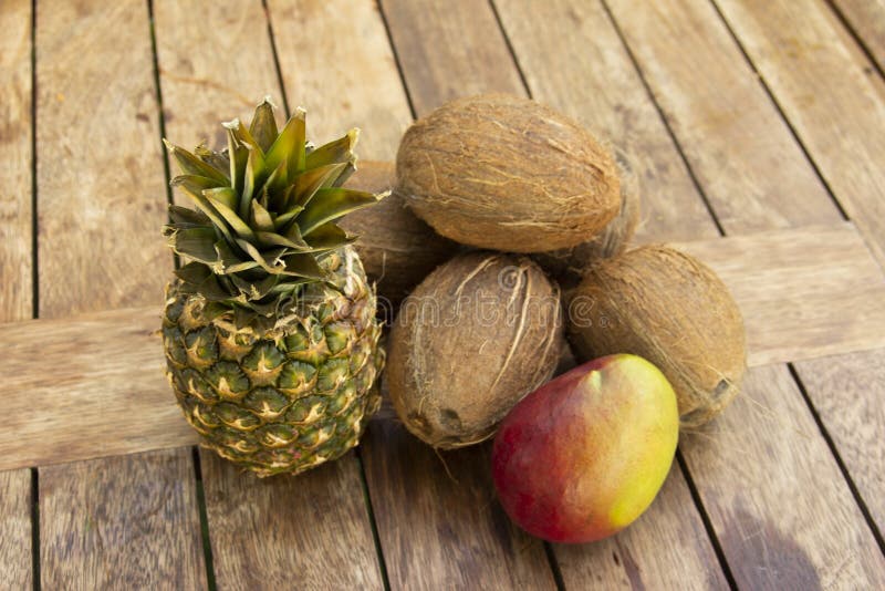 La photo d'un ananas, de noix de coco et de mangue sur la table en bois Cuisine végétarienne et saine Nutrition et régime aliment