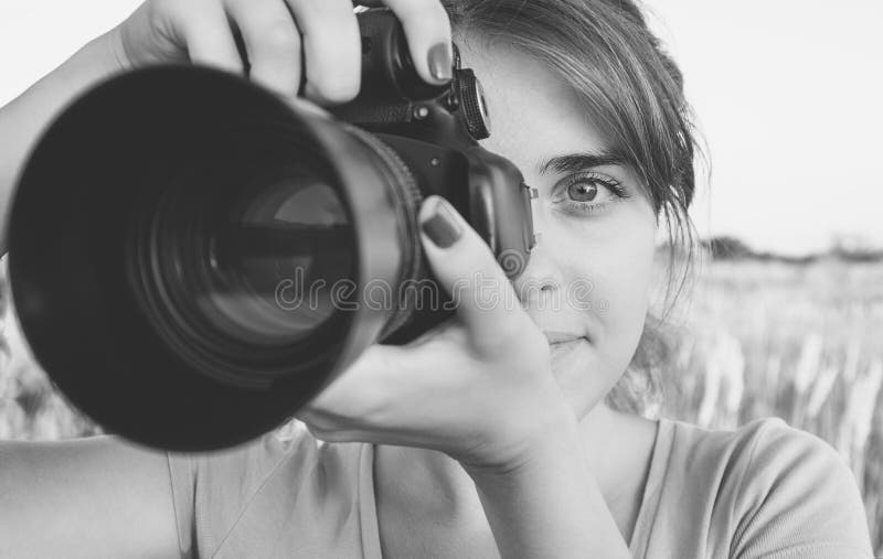 La photo noire et blanche de la fille regardant dans le viseur d'appareil-photo a in camera visé la nature photo libre de droits La photo noire et blanche de la fille regardant dans le viseur d'appareil-photo a in camera visé la nature photo libre de droits