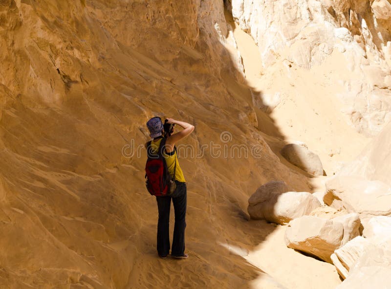 La photographe de fille prend des photos des montagnes dans le canyon en Egypte Dahab Sinai du sud images stock La photographe de fille prend des photos des montagnes dans le canyon en Egypte Dahab Sinai du sud images stock