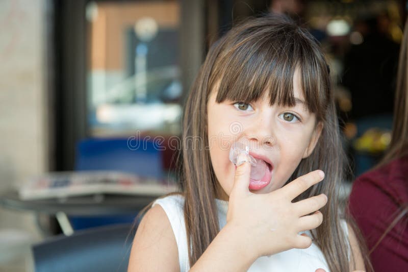 la piccola bambina lecca le sue dita fotografia stock libera da diritti la piccola bambina lecca le sue dita fotografia stock libera da diritti