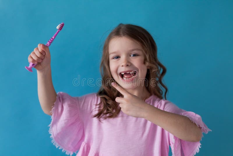 La piccola bella ragazza pulisce l'odontoiatria dello spazzolino da denti dei denti fotografia stock La piccola bella ragazza pulisce l'odontoiatria dello spazzolino da denti dei denti fotografia stock