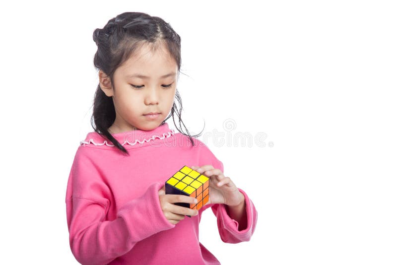 La piccola ragazza abile asiatica risolve il puzzle fotografia stock libera da diritti La piccola ragazza abile asiatica risolve il puzzle fotografia stock libera da diritti