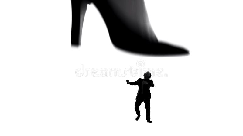 La pierna en los tacones altos que caminan en pequeño hombre débil, dominación femenina de la mujer en pares imagen de archivo La pierna en los tacones altos que caminan en pequeño hombre débil, dominación femenina de la mujer en pares imagen de archivo
