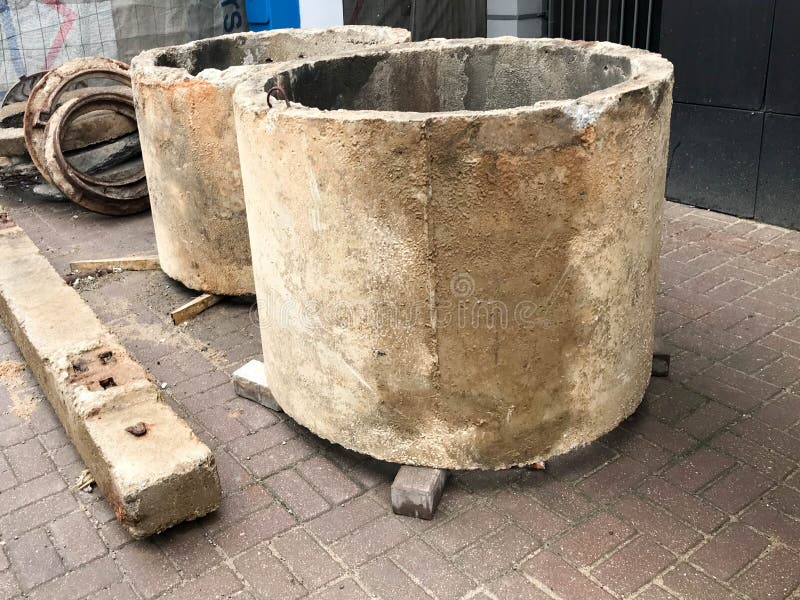 La pierre concrète de ciment de grand rond entoure des puits d'anneaux à un chantier de construction image libre de droits La pierre concrète de ciment de grand rond entoure des puits d'anneaux à un chantier de construction image libre de droits