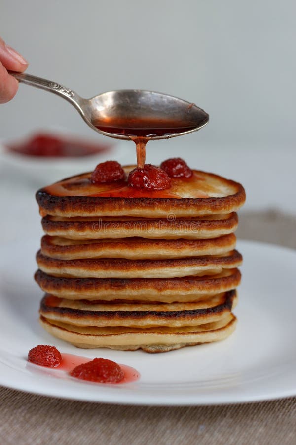 La pile de crêpes américaines avec de la confiture de fraise se trouvent d'un plat blanc photo libre de droits La pile de crêpes américaines avec de la confiture de fraise se trouvent d'un plat blanc photo libre de droits