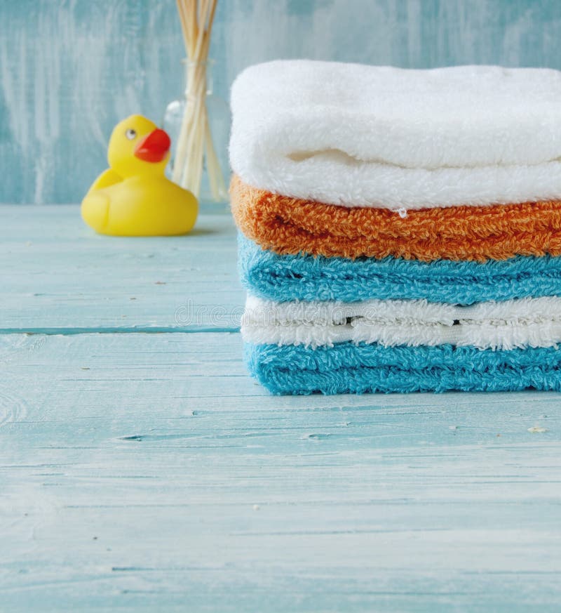 La pile de serviettes colorées et le bain se penchent sur la table photographie stock La pile de serviettes colorées et le bain se penchent sur la table photographie stock