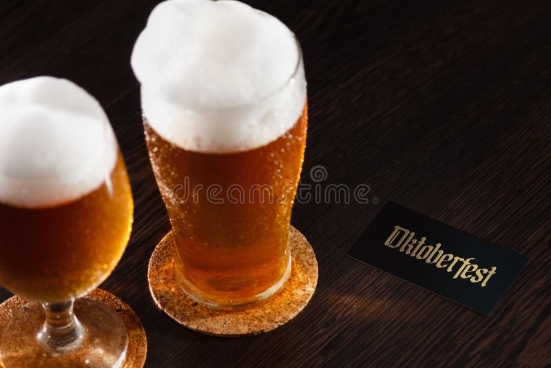La pinte en verre de bière sur un fond en bois avec la mousse et l'Oktoberfest textotent photo stock La pinte en verre de bière sur un fond en bois avec la mousse et l'Oktoberfest textotent photo stock