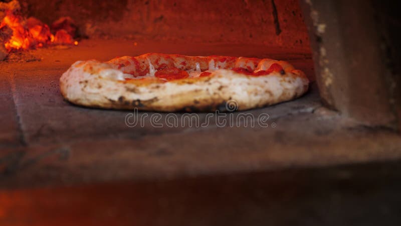 La pizza di chiusura viene cotta in un tradizionale forno a fuoco in legno con tronchi di combustione.