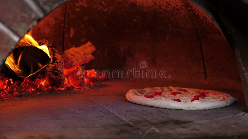 La pizza di chiusura viene cotta in un tradizionale forno a fuoco in legno con tronchi di combustione.