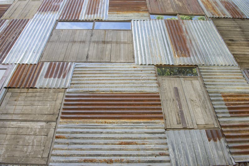 La placa de metal y la madera oxidadas emparedan el fondo con las ventanas foto de archivo La placa de metal y la madera oxidadas emparedan el fondo con las ventanas foto de archivo