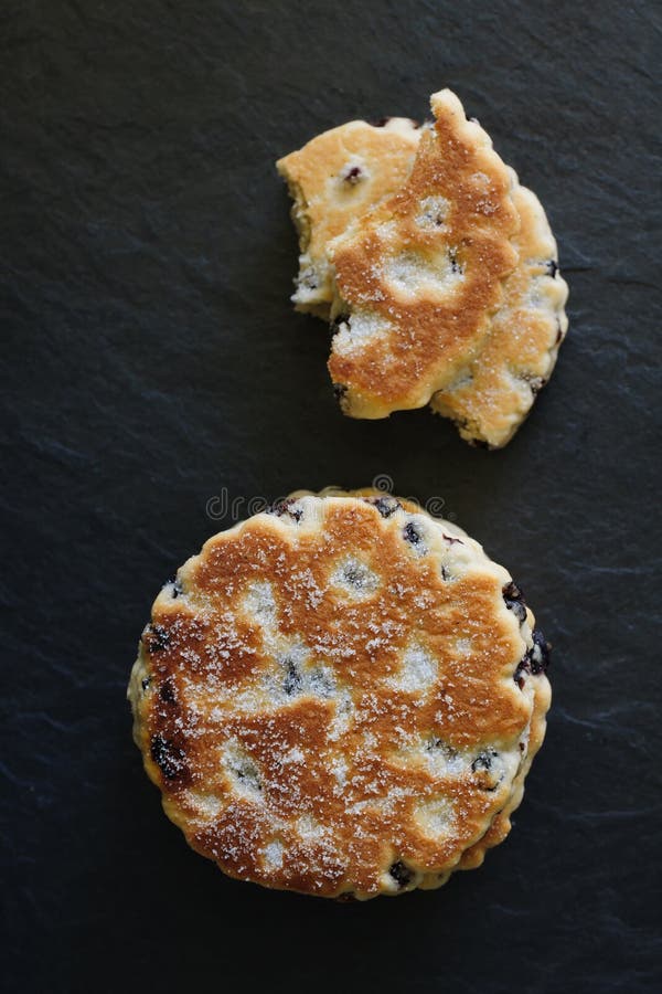 Welsh cakes a traditional griddle cake made with flour and dried fruit on a slate background. Welsh cakes a traditional griddle cake made with flour and dried fruit on a slate background