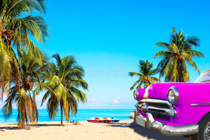 La playa tropical de Varadero en Cuba con el clásico coche norteamericano rosa, veleros y palmeras en un día de verano con turque imagen de archivo libre de regalías La playa tropical de Varadero en Cuba con el clásico coche norteamericano rosa, veleros y palmeras en un día de verano con turque imagen de archivo libre de regalías