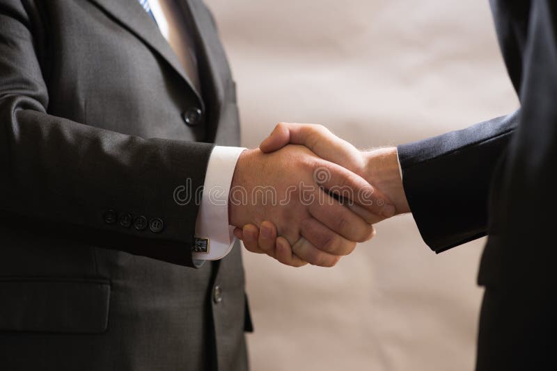 La poignée de main d'affaires de deux hommes d'affaires dans les costumes, négocient et font une affaire images libres de droits La poignée de main d'affaires de deux hommes d'affaires dans les costumes, négocient et font une affaire images libres de droits