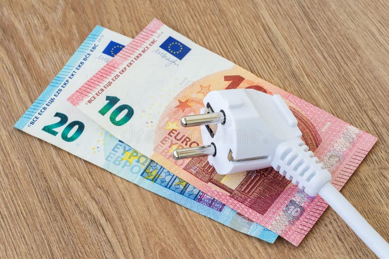 La prise d'énergie blanche sur les billets en euros sur une surface en bois brun Concept énergétique coûteux et coût de l'électri photos stock La prise d'énergie blanche sur les billets en euros sur une surface en bois brun Concept énergétique coûteux et coût de l'électri photos stock