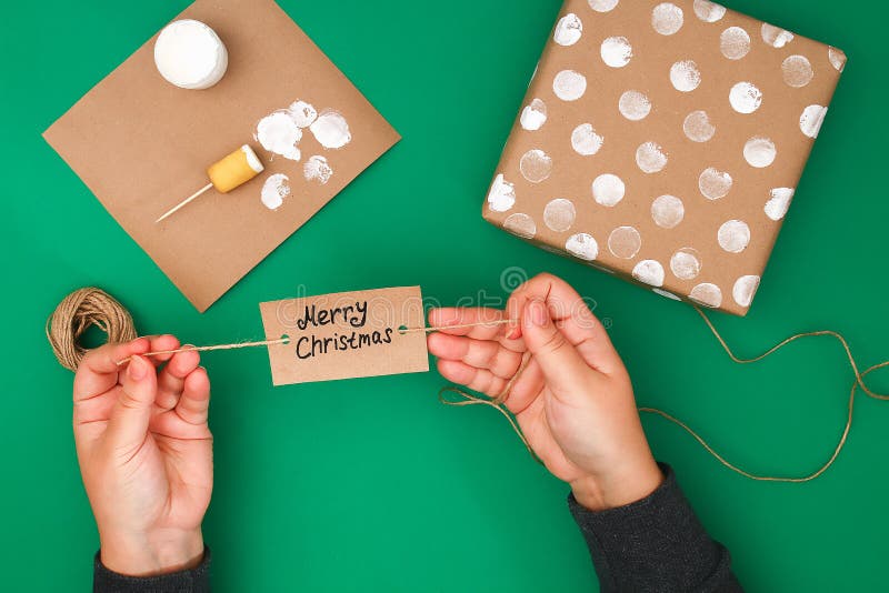 La progettazione originale di un regalo di Natale della carta del mestiere, pittura bianca, un bollo delle patate Per gradi sulla fotografia stock La progettazione originale di un regalo di Natale della carta del mestiere, pittura bianca, un bollo delle patate Per gradi sulla fotografia stock