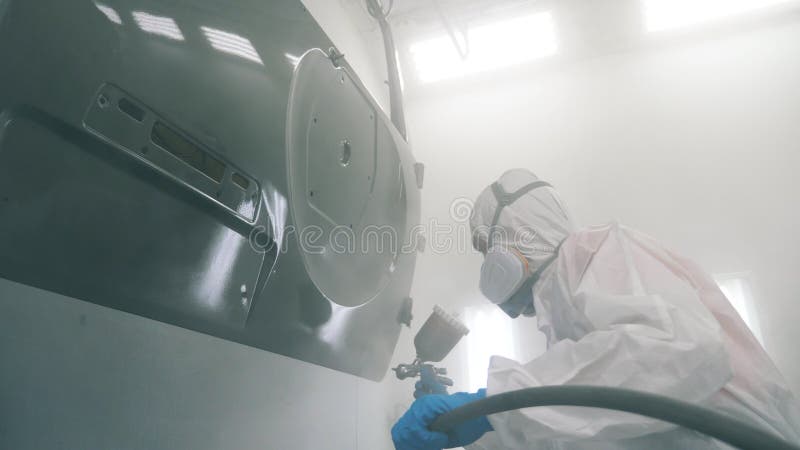 La puerta del auto estÃ¡ siendo coloreada por el trabajador del garaje. Proceso de pintura por pulverizaciÃ³n industrial