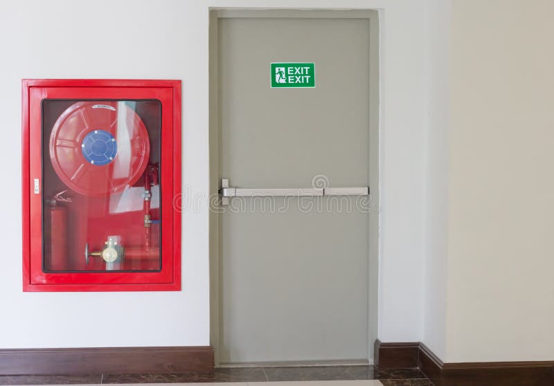 La puerta y el fuego de la salida de socorro extinguen el equipo imagen de archivo La puerta y el fuego de la salida de socorro extinguen el equipo imagen de archivo