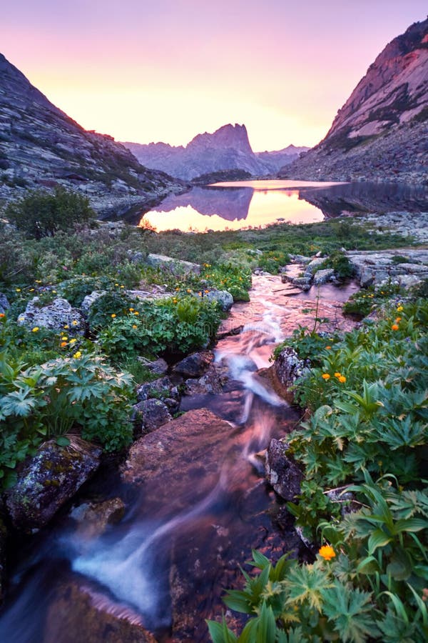 La puesta del sol en montañas acerca al río Luz del sol reflejada en los tops de la montaña La luz de oro del cielo reflejó en un imagenes de archivo La puesta del sol en montañas acerca al río Luz del sol reflejada en los tops de la montaña La luz de oro del cielo reflejó en un imagenes de archivo