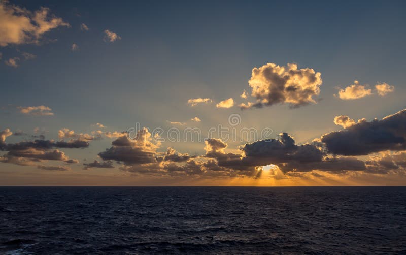 La puesta del sol y el sistema dramático de nubes que derivan sobre las aguas tropicales del mar del Caribe se encienden por los fotografía de archivo libre de regalías La puesta del sol y el sistema dramático de nubes que derivan sobre las aguas tropicales del mar del Caribe se encienden por los fotografía de archivo libre de regalías