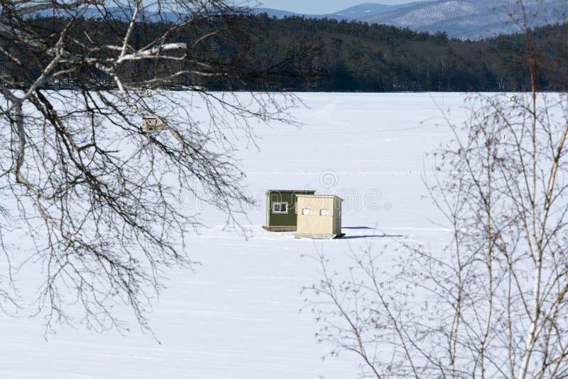 La pêche de glace en Bob Houses sur la neige a couvert le lac dans le nouvel anglais ; et images libres de droits La pêche de glace en Bob Houses sur la neige a couvert le lac dans le nouvel anglais ; et images libres de droits