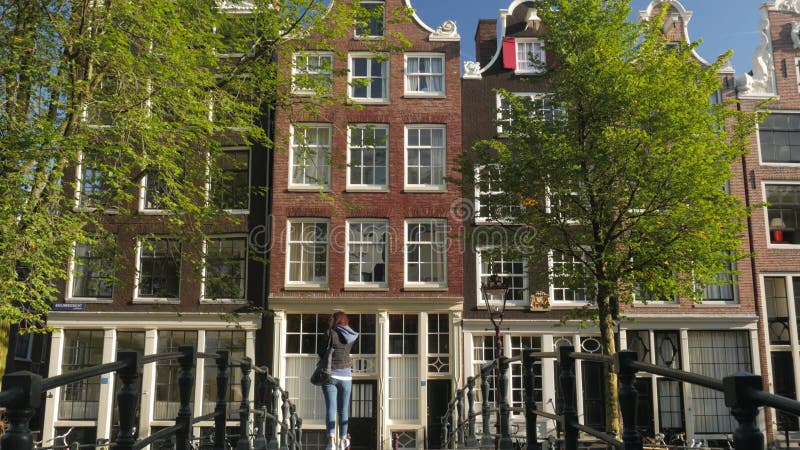 La ragazza cammina sopra la passerella sul canale di Brouwersgracht a Amsterdam