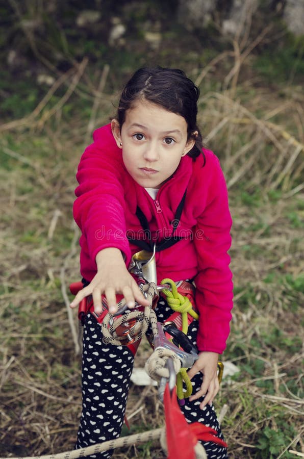 La ragazza con attrezzatura rampicante ha bisogno dell'aiuto Sport ed attività avventura fotografia stock La ragazza con attrezzatura rampicante ha bisogno dell'aiuto Sport ed attività avventura fotografia stock