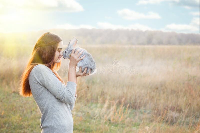 La ragazza con il coniglio felice fotografia stock La ragazza con il coniglio felice fotografia stock