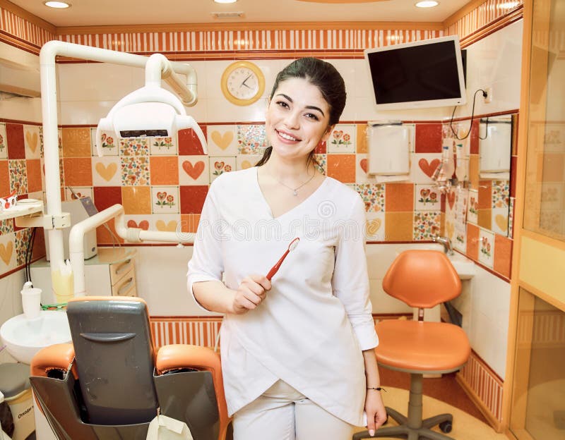 La ragazza del dentista dei bambini all'ufficio del dentista tiene il vostro spazzolino da denti fotografie stock La ragazza del dentista dei bambini all'ufficio del dentista tiene il vostro spazzolino da denti fotografie stock