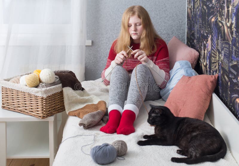 La ragazza dell'adolescente tricotta a casa immagine stock La ragazza dell'adolescente tricotta a casa immagine stock