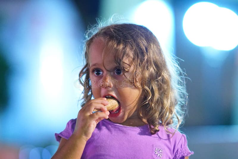 La ragazza di 3 anni mangia un gelato fotografie stock La ragazza di 3 anni mangia un gelato fotografie stock