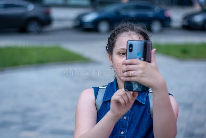 La ragazza fa la foto sullo smartphone ragazza di vita moderna con lo smartphone immagine stock La ragazza fa la foto sullo smartphone ragazza di vita moderna con lo smartphone immagine stock