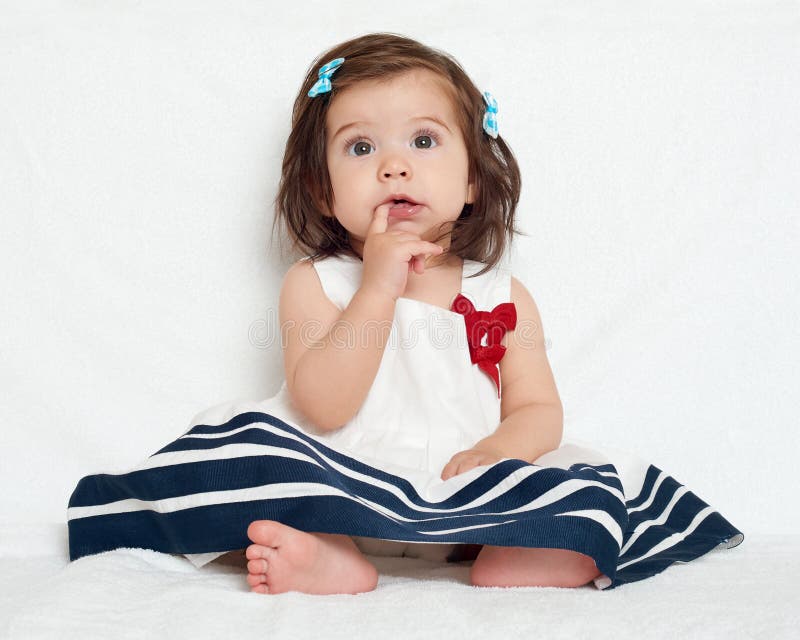 La ragazza felice del piccolo bambino si siede sull'asciugamano bianco, sull'emozione felice e sull'espressione del fronte, molto fotografia stock La ragazza felice del piccolo bambino si siede sull'asciugamano bianco, sull'emozione felice e sull'espressione del fronte, molto fotografia stock