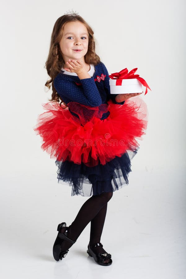 La ragazza felice di Santa sta tenendo il contenitore di regalo, natale fotografie stock libere da diritti La ragazza felice di Santa sta tenendo il contenitore di regalo, natale fotografie stock libere da diritti
