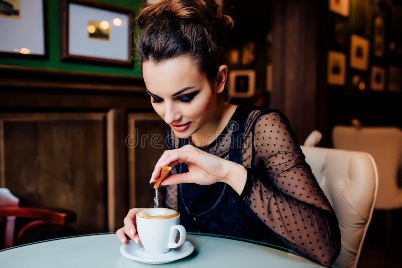 La ragazza felice ha tazza di caffè all'interno fotografia stock libera da diritti La ragazza felice ha tazza di caffè all'interno fotografia stock libera da diritti