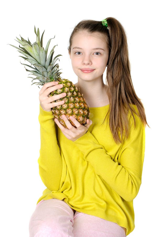 La ragazza graziosa sta tenendo un grande ananas fotografia stock libera da diritti La ragazza graziosa sta tenendo un grande ananas fotografia stock libera da diritti
