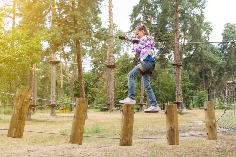 La ragazza ha 10 anni nell'avventura che scala il parco dell'alto cavo, stile di vita attivo dei bambini fotografia stock libera da diritti La ragazza ha 10 anni nell'avventura che scala il parco dell'alto cavo, stile di vita attivo dei bambini fotografia stock libera da diritti
