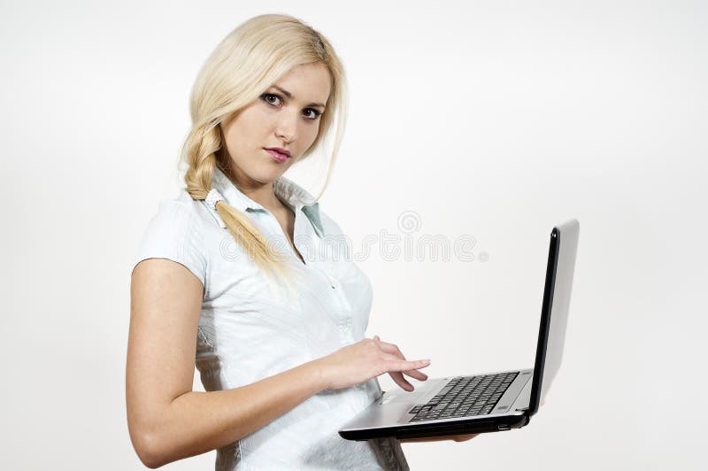 La ragazza lavora ad un computer portatile immagine stock libera da diritti La ragazza lavora ad un computer portatile immagine stock libera da diritti