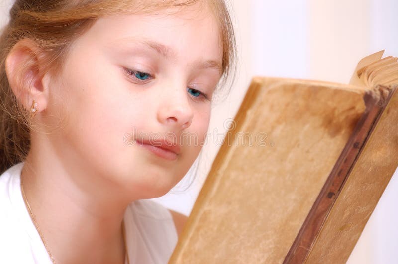 Una ragazza legge un libro antico fotografia stock