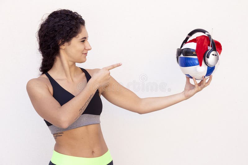 La ragazza mostra un pallone da calcio con i vetri fotografia stock La ragazza mostra un pallone da calcio con i vetri fotografia stock